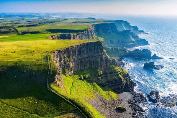 Basalt cliffs and green fields on the Causeway Coast, Northern Ireland